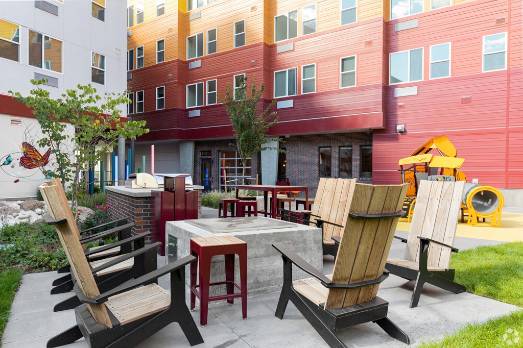 A patio with chairs and a table in front of a building.
