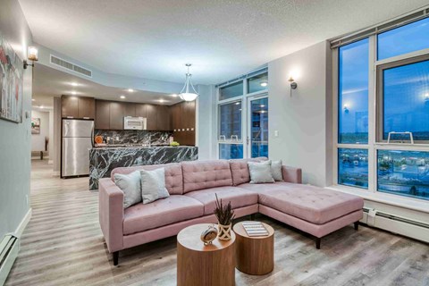 A living room with a pink couch and a marble backsplash.