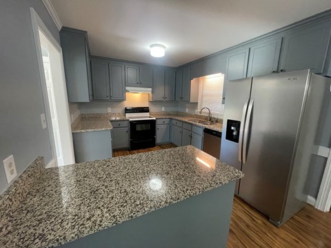 A kitchen with granite countertops and stainless steel appliances.