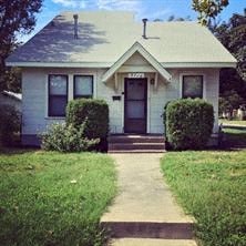 A small house with a front porch and a mailbox on the front door.