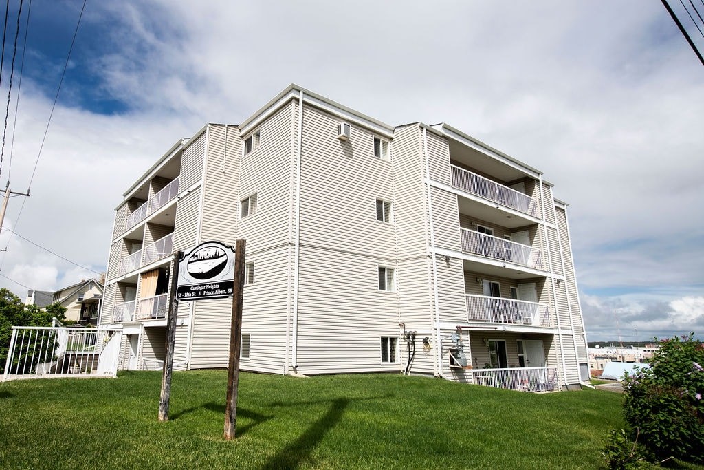 A tall apartment building with a sign in front of it.