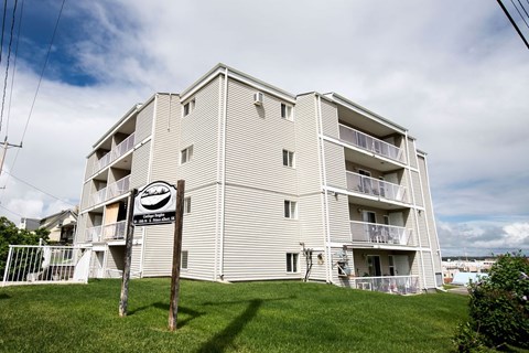 A tall apartment building with a sign in front of it.