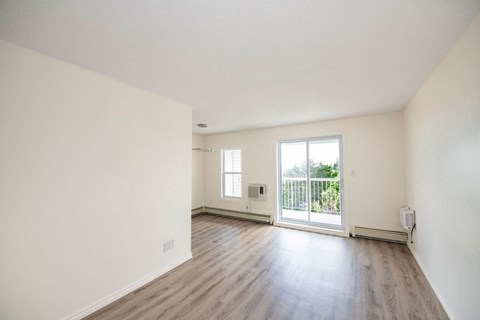A room with a sliding glass door leading to a balcony.