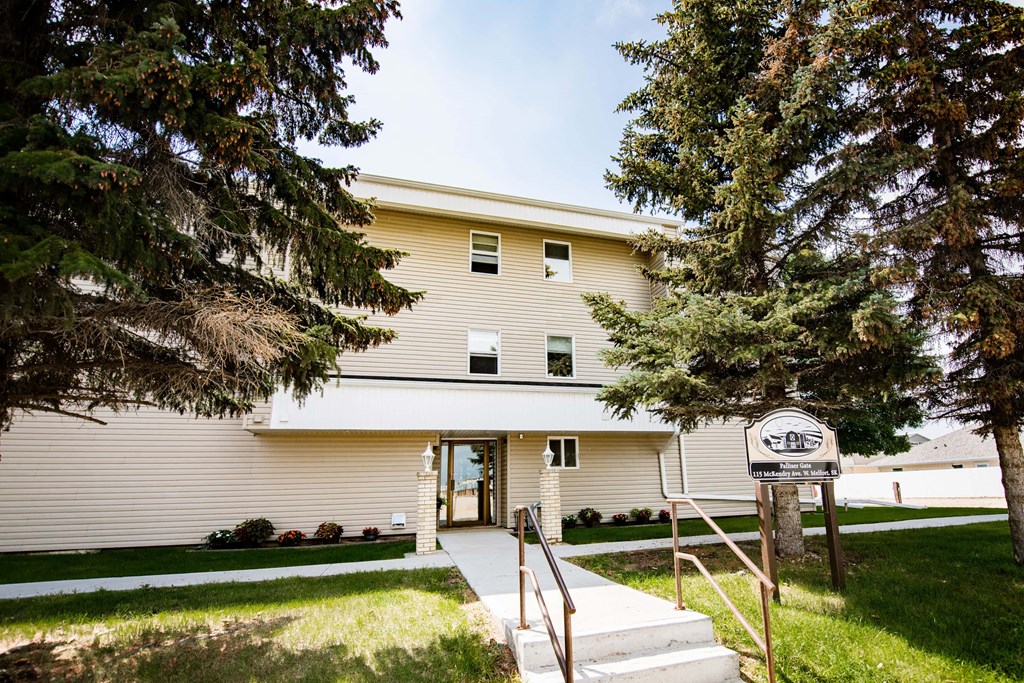 A white building with a sign in front of it.
