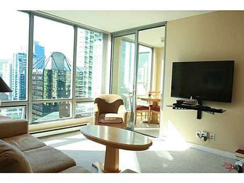 A living room with a flat screen TV mounted on the wall.