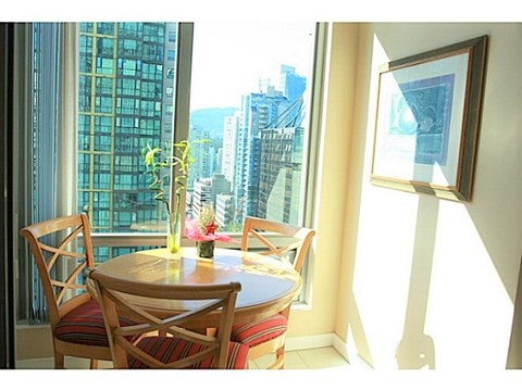 A dining room with a table and chairs and a view of the city.
