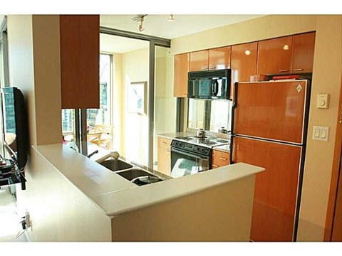 A kitchen with a white counter top and brown cabinets.