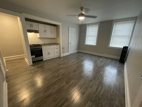 A room with a wood floor and a ceiling fan.