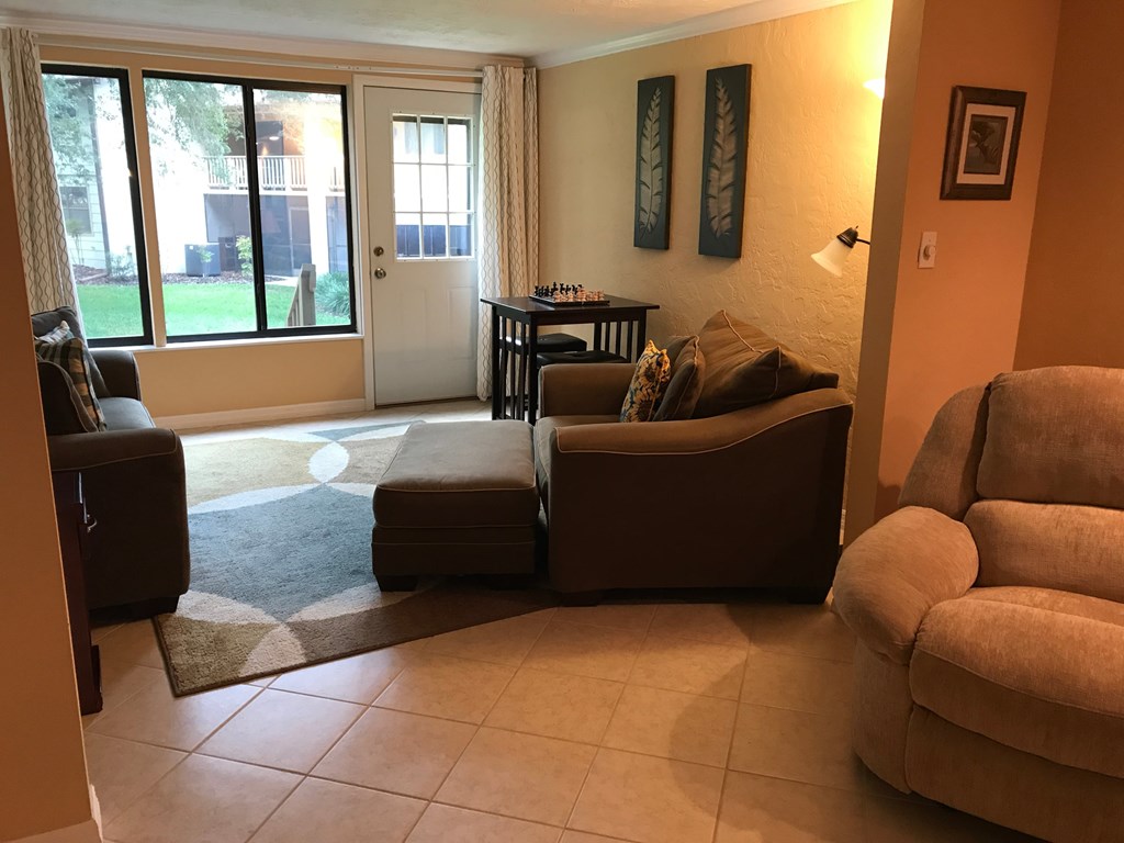 A living room with a brown couch, a chair, and a table.