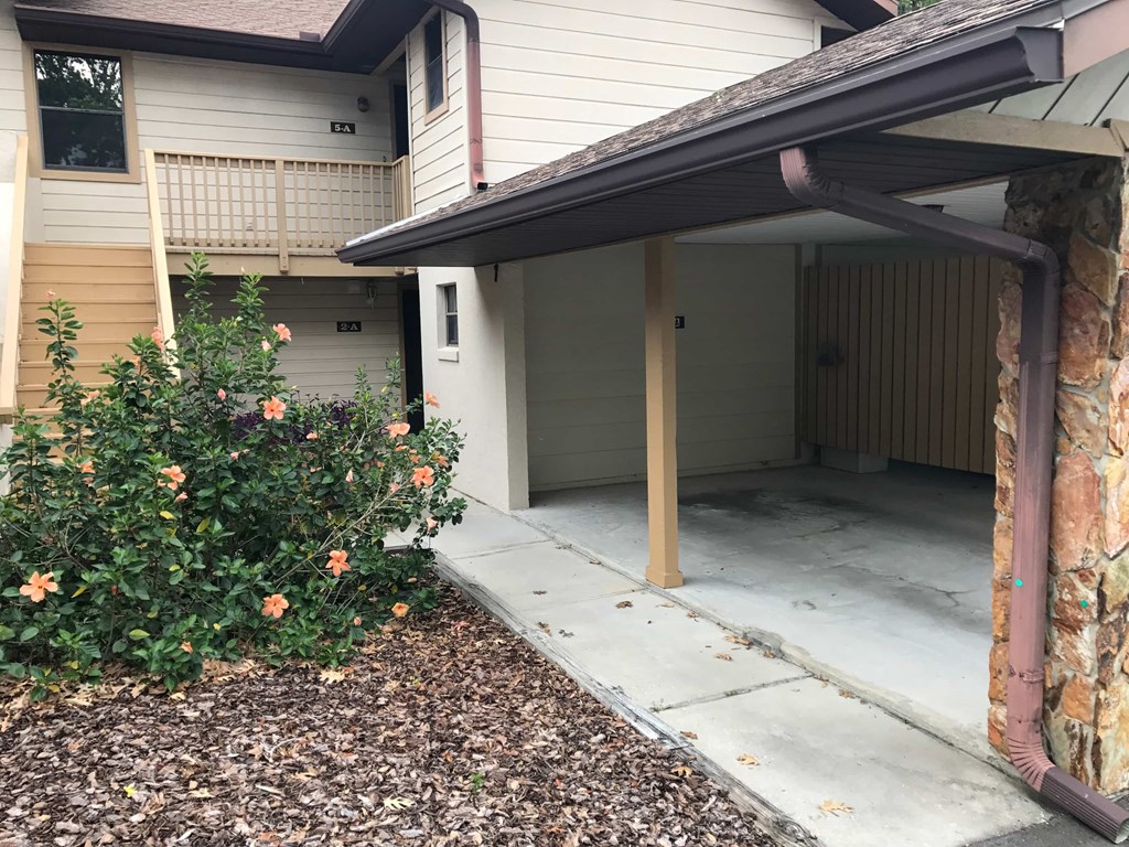 A house with a covered patio and a garden in front.