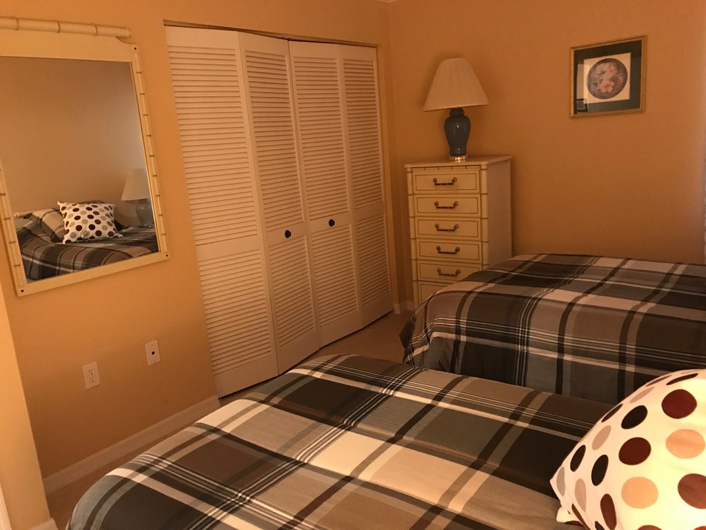 A bedroom with a bed, dresser, and mirror.