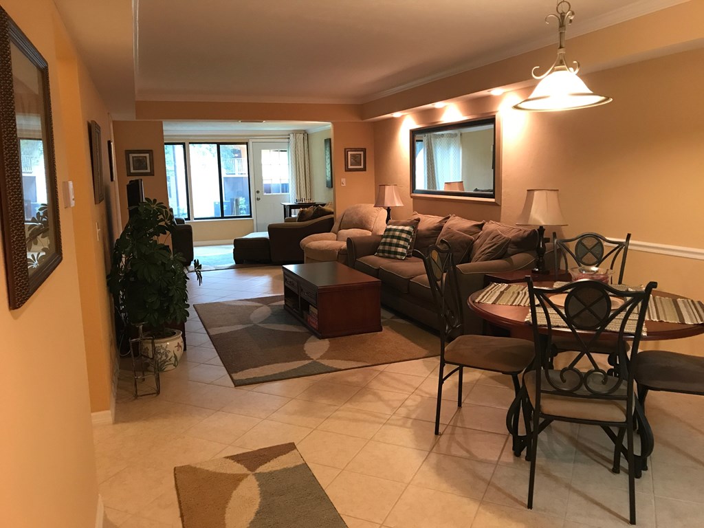 A living room with a couch, chairs, and a dining table.