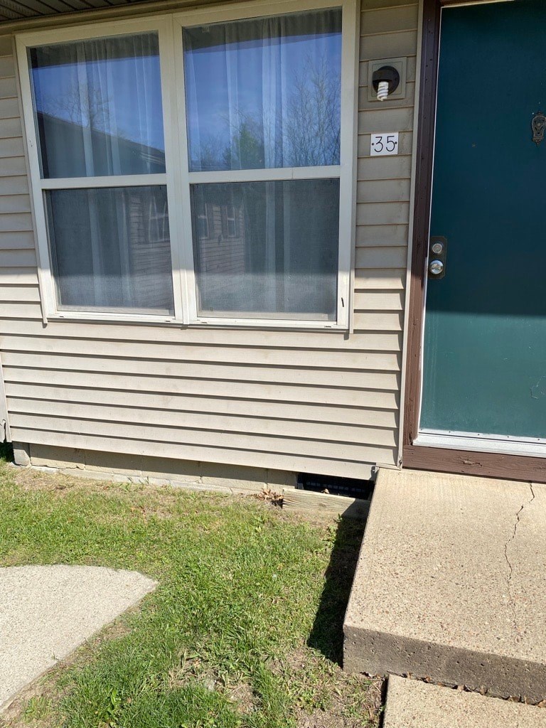 A house numbered 35 with a blue door and a window with curtains.