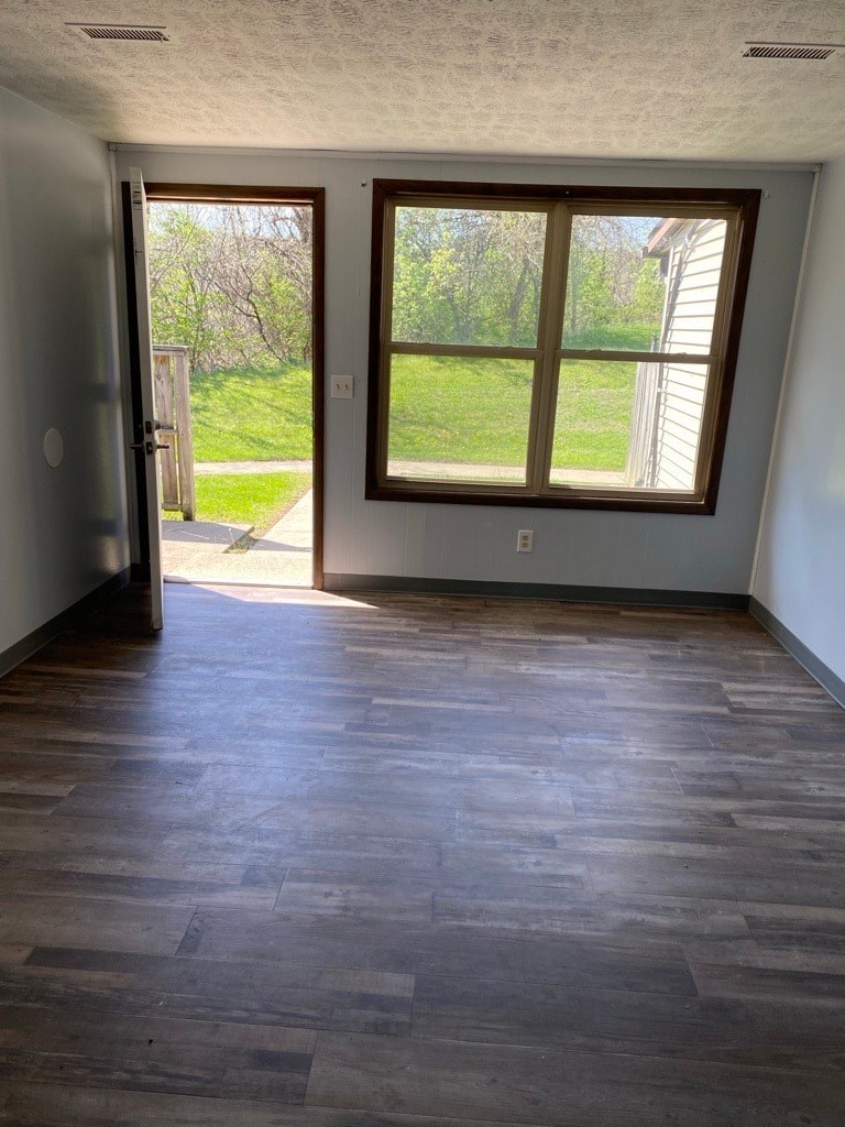 A room with a large window and wooden flooring.