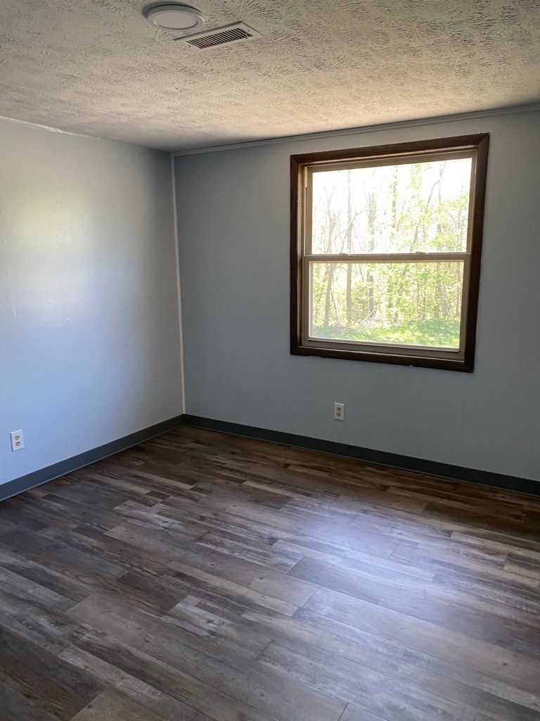 A room with a window and wood flooring.