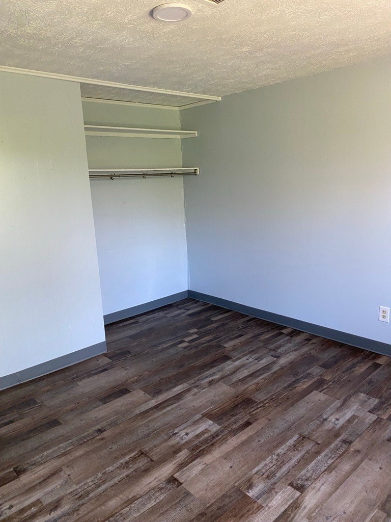 A room with wooden flooring and a white wall.