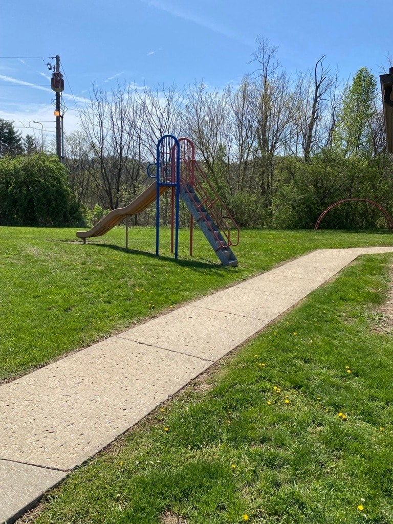 A playground with a slide and a walkway.
