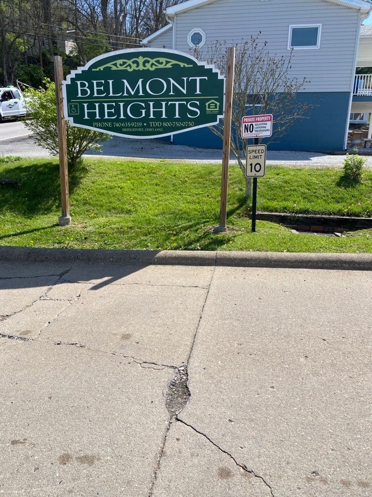 A sign that says Belmont Heights is on a green background.