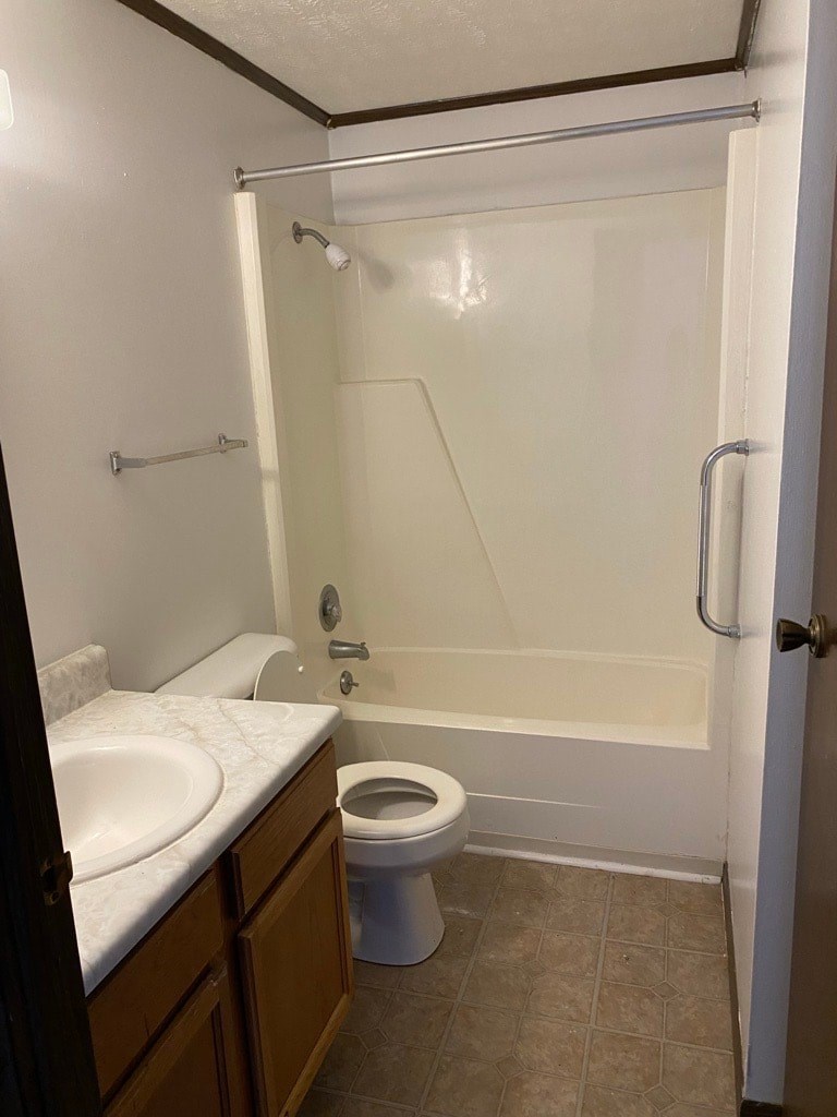A white toilet is in a bathroom with a walk-in shower.