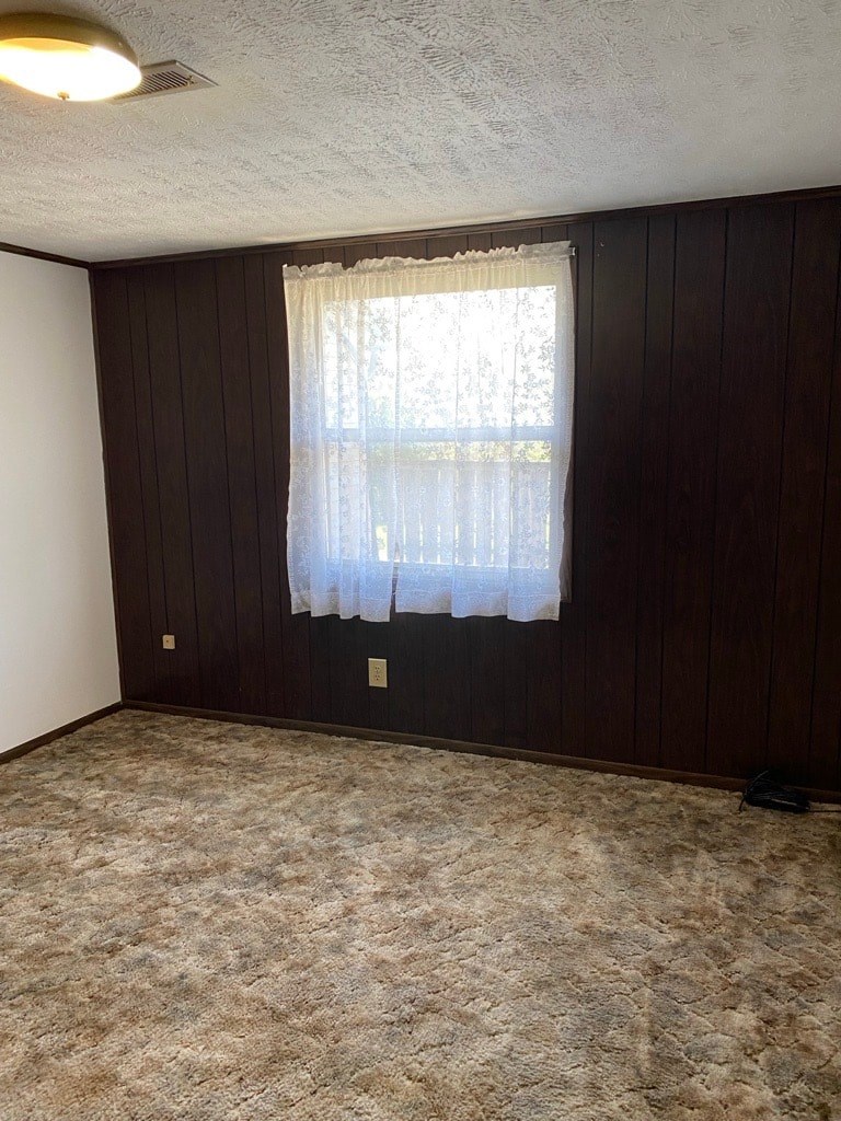 A room with a window covered by a white curtain.