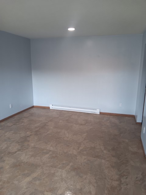 A room with a light brown floor and white walls.