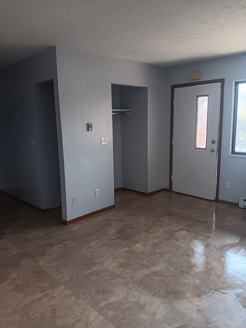 A room with a door, a window, and a wall socket.