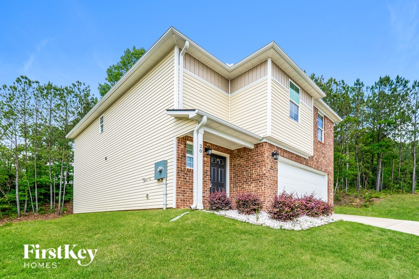 A house with a beige siding and a brick chimney is for sale by FirstKey Homes.