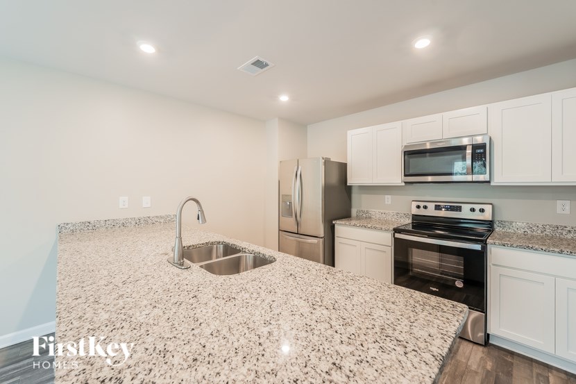 A kitchen with granite countertops and stainless steel appliances.