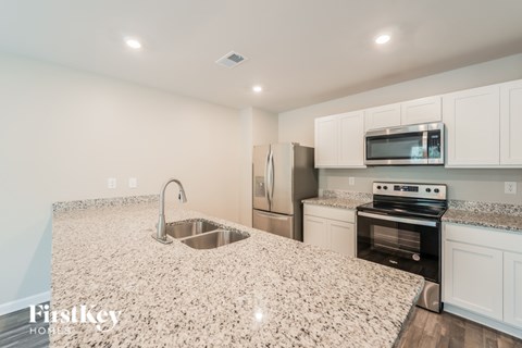 A kitchen with granite countertops and stainless steel appliances.