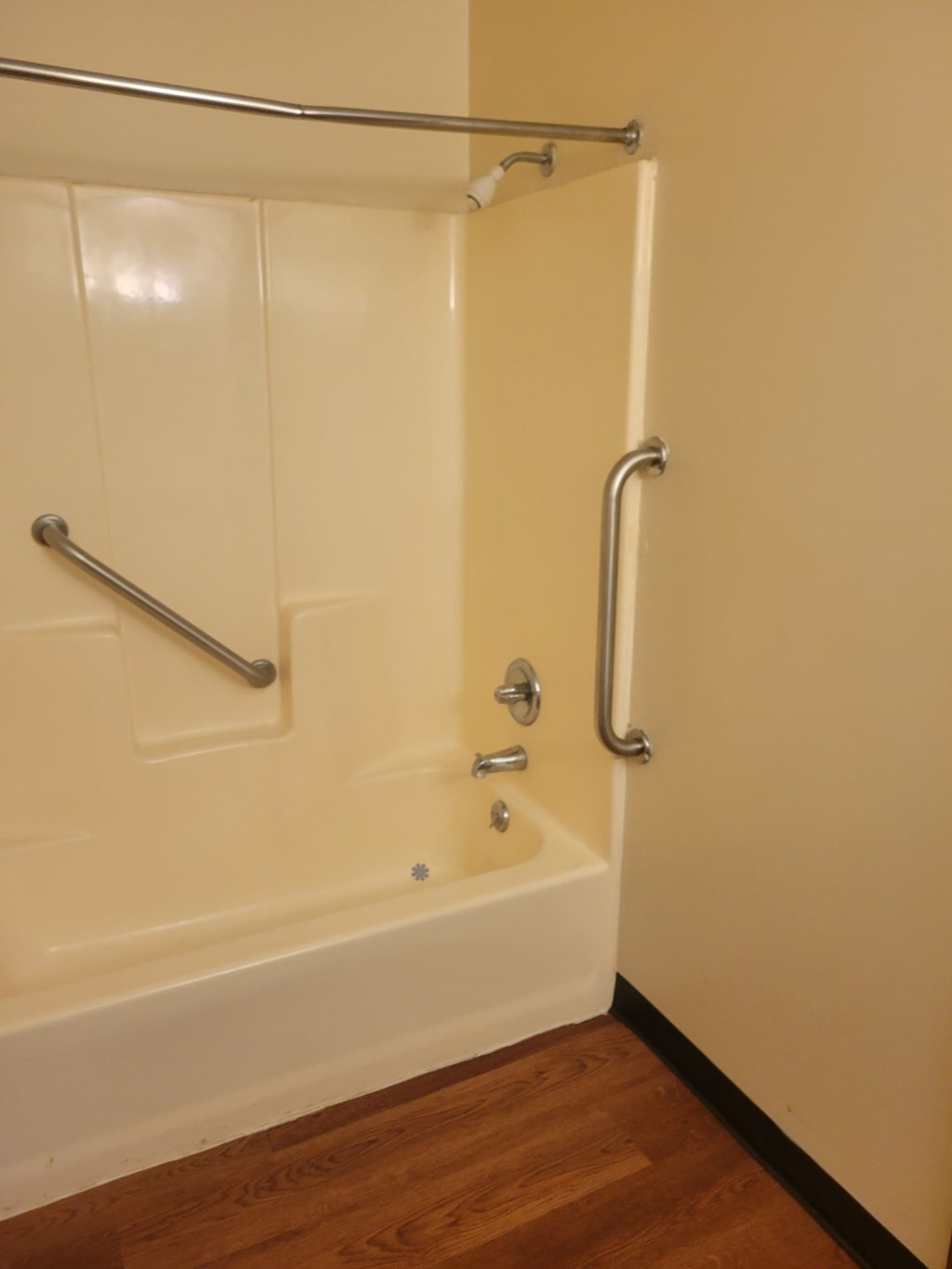 A white bathtub with a silver faucet and grab bar.