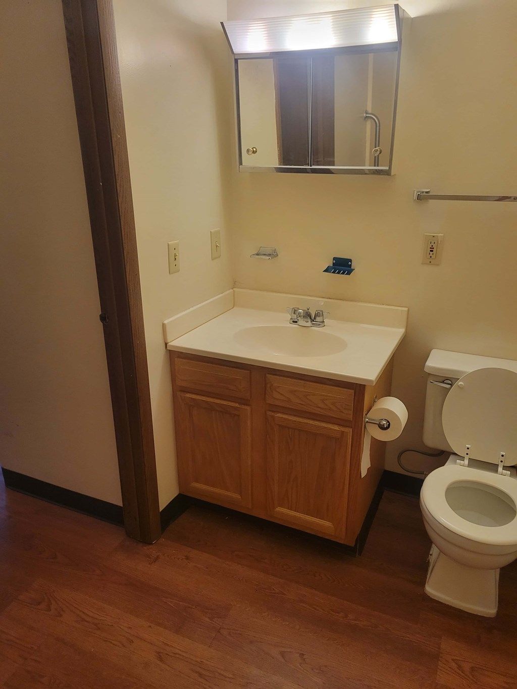 A white toilet sits next to a sink in a small bathroom.
