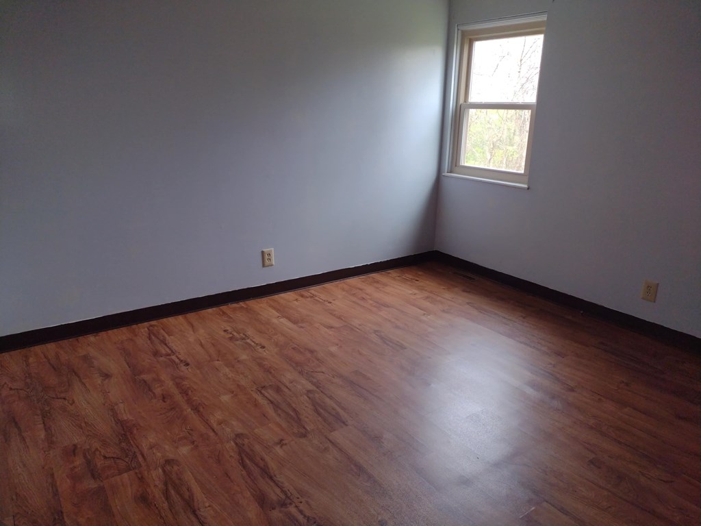 A room with a window and wooden floors.