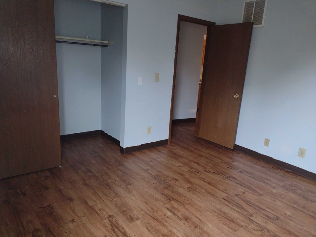 A room with wood floors and two doors.