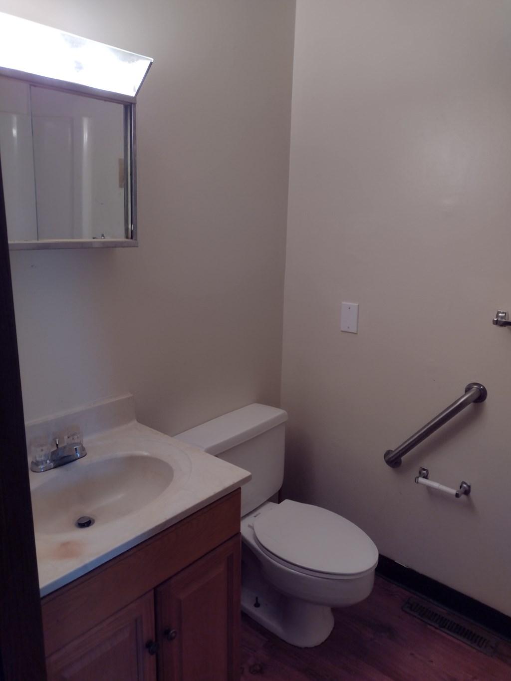 A white toilet sits next to a sink in a small bathroom.