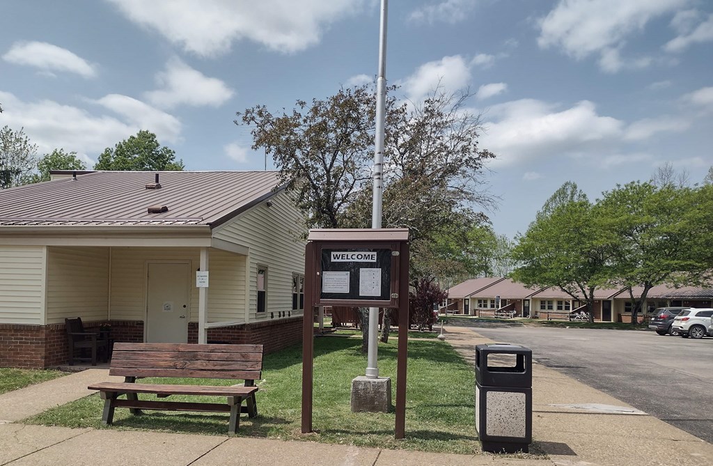 A sign that says "Welcome" stands in front of a building.