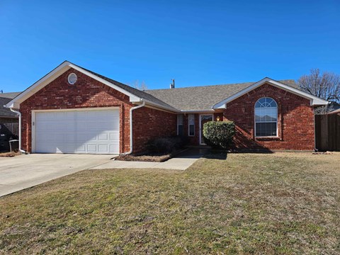A red brick house with a white garage door.