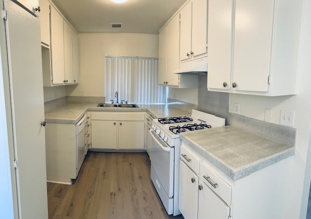 A kitchen with white cabinets and a stove top oven.