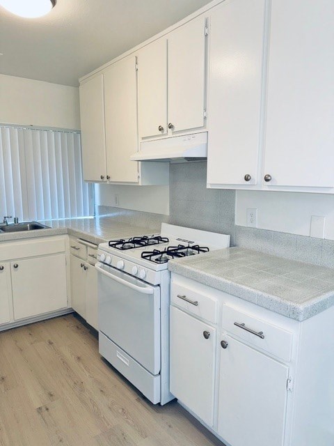 A white kitchen with a stove and cabinets.