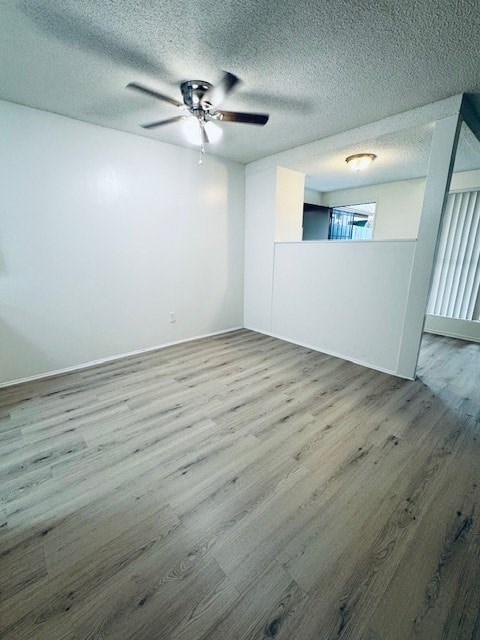 A room with a ceiling fan and wooden flooring.