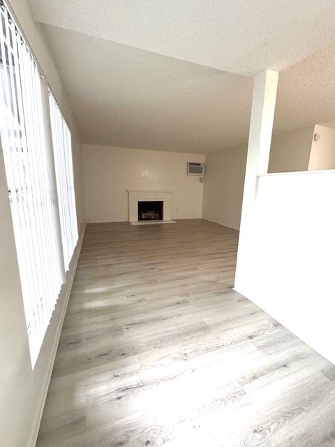 A room with a fireplace and wood flooring.
