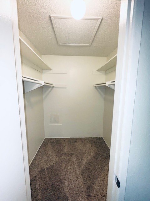 A small, empty room with a carpeted floor and a single light fixture on the ceiling.