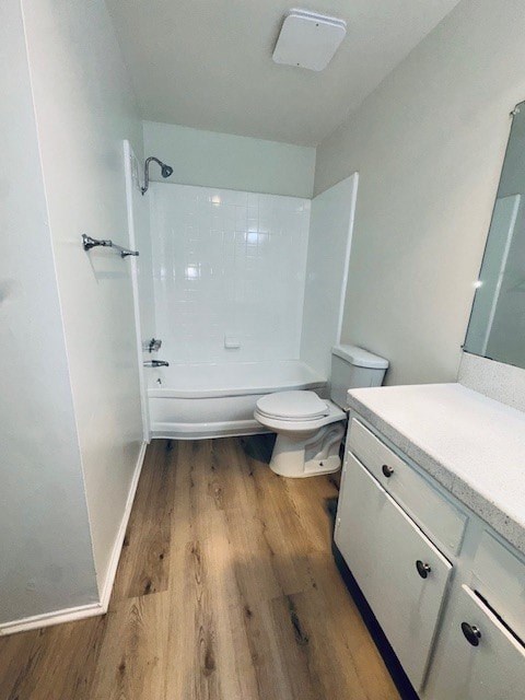 A white bathroom with wood flooring and a walk-in shower.