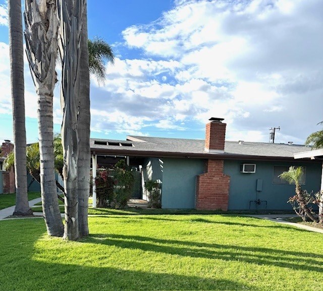 A house with a blue exterior and a red brick chimney.