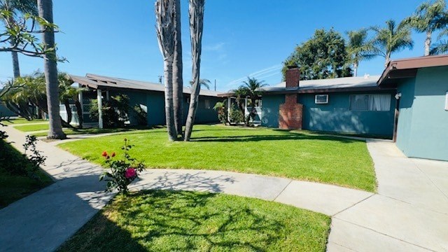 A house with a green lawn and a flower bed in front.