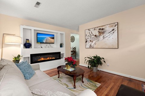 A living room with a fireplace and a painting on the wall.