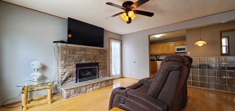 A living room with a brown recliner chair and a fireplace.