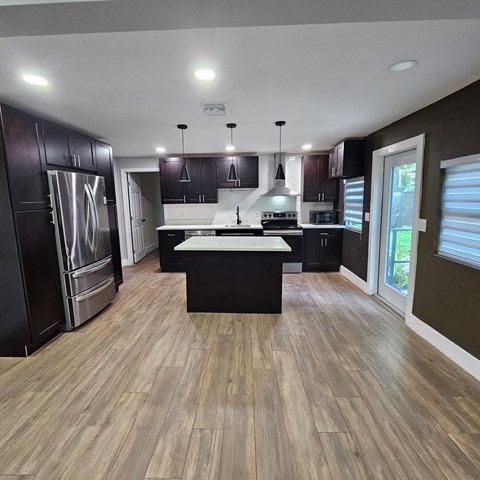 A modern kitchen with dark wood cabinets and a central island.