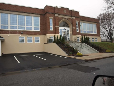 A building with a parking lot in front.