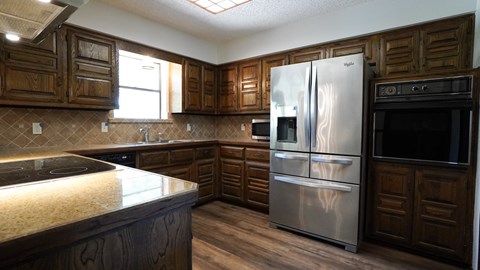 A kitchen with wooden cabinets and stainless steel appliances.