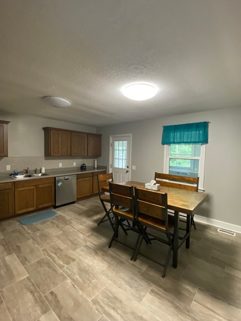 A kitchen with a table and chairs.